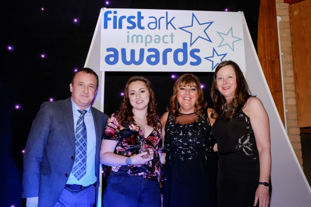 Keri Romano, Project Coordinator holding the trophy, next to Joyce Greaves, CEO who are both flanked by Neil Fitzmaurice, compere for the event and Jane Trevithick from Anthony Collins Solicitors who sponsored the award.
